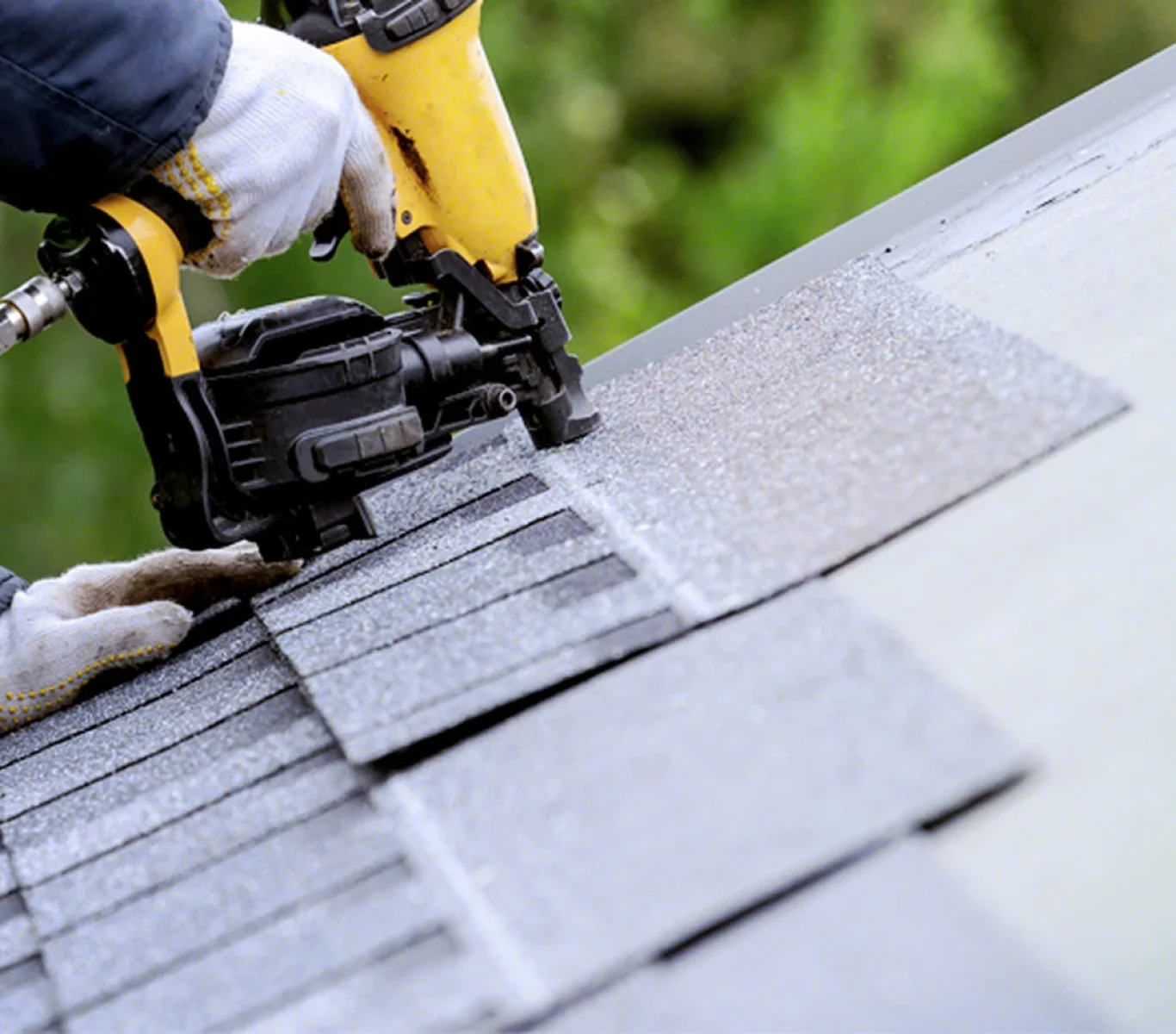 Crew removing old shingles during a Nebraska roof replacement