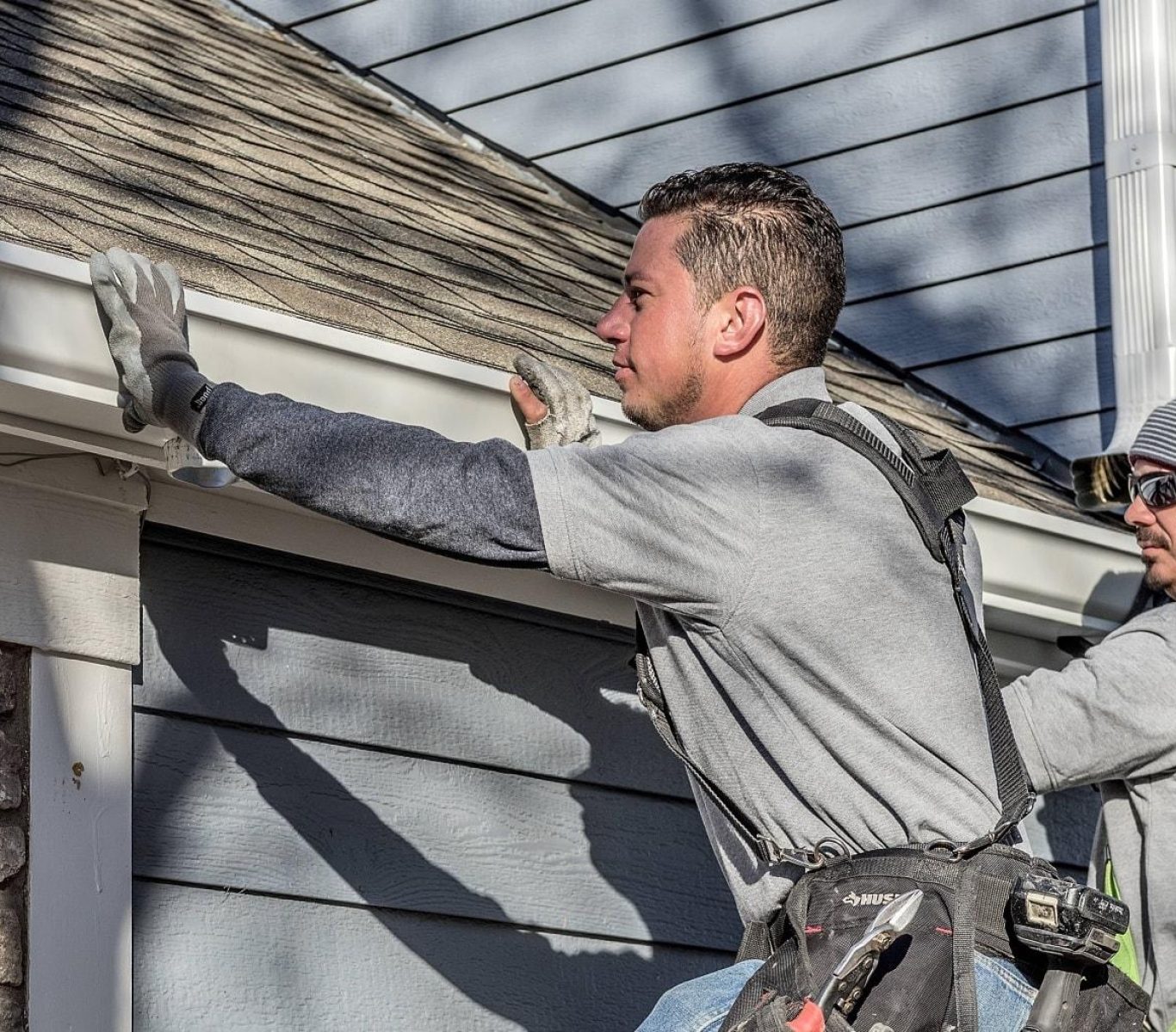 Crew installing seamless aluminum gutters on a home in Nebraska