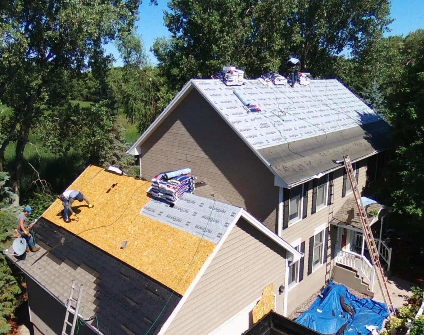 Roof installation crew tying a new plane into an older Lincoln house