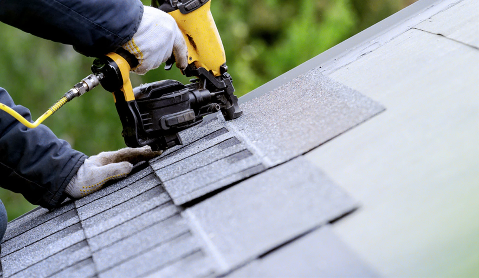 Crew removing old shingles during a Nebraska roof replacement