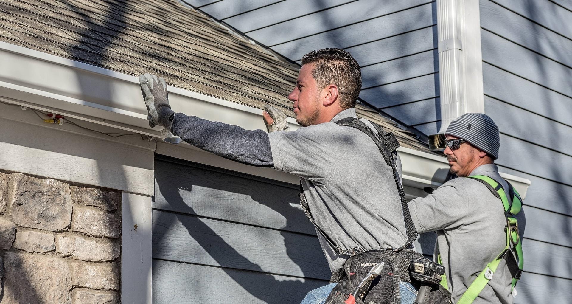 Crew installing seamless aluminum gutters on a home in Nebraska